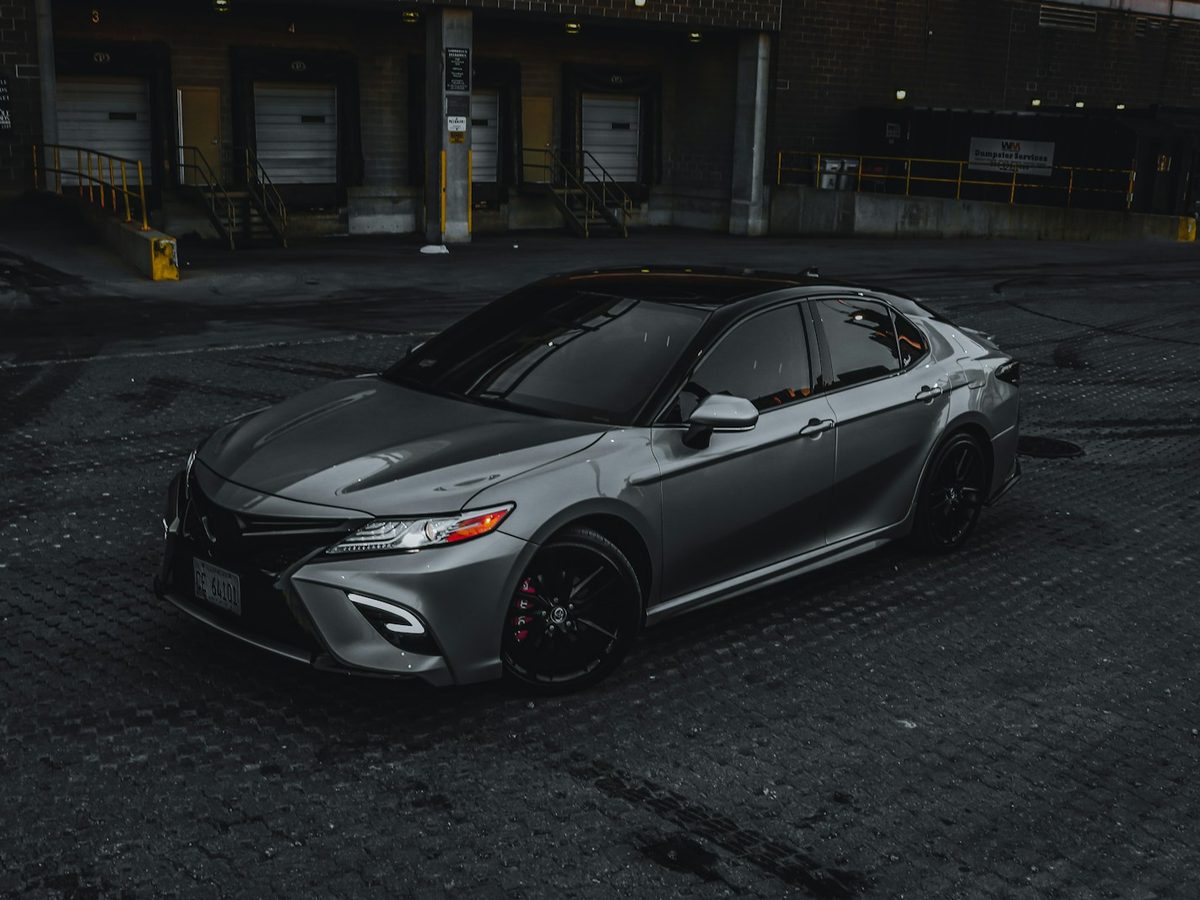 A grey midsize sedan parked on a paved lot
