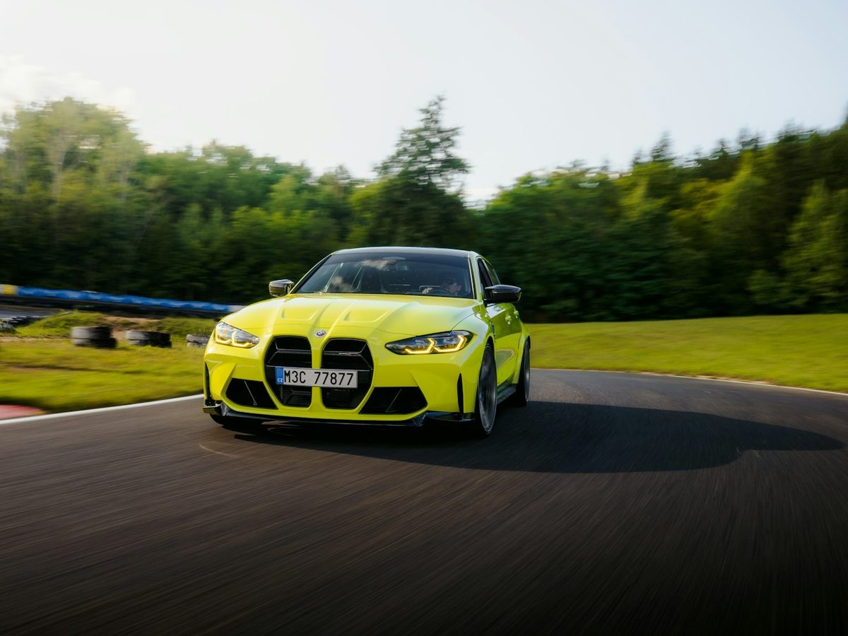 A lime green sports sedan cornering on a race track